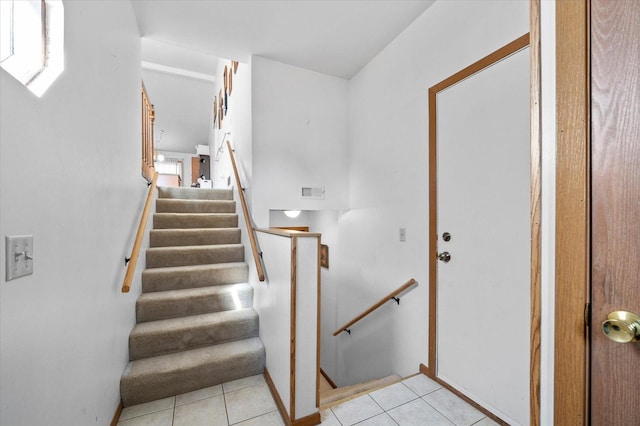 stairway with tile patterned flooring and visible vents