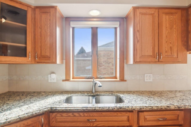 kitchen featuring brown cabinets, a sink, and decorative backsplash