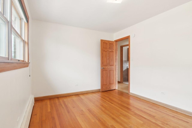 spare room with light wood-style flooring, baseboards, and baseboard heating