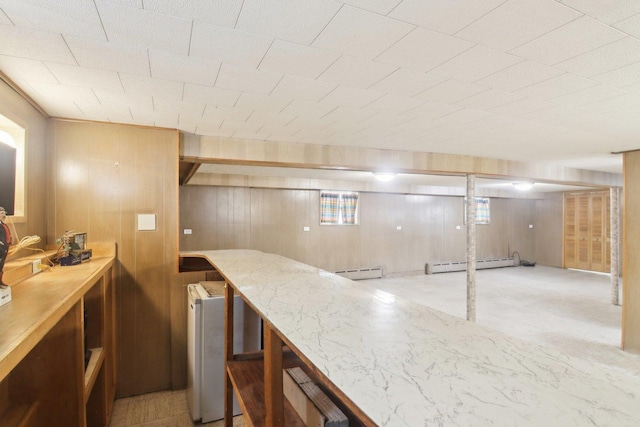 bar featuring wood walls and baseboard heating