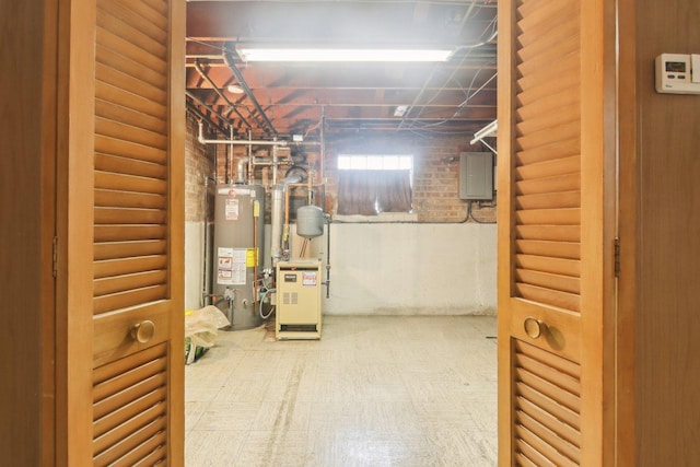 basement with brick wall, a heating unit, and gas water heater