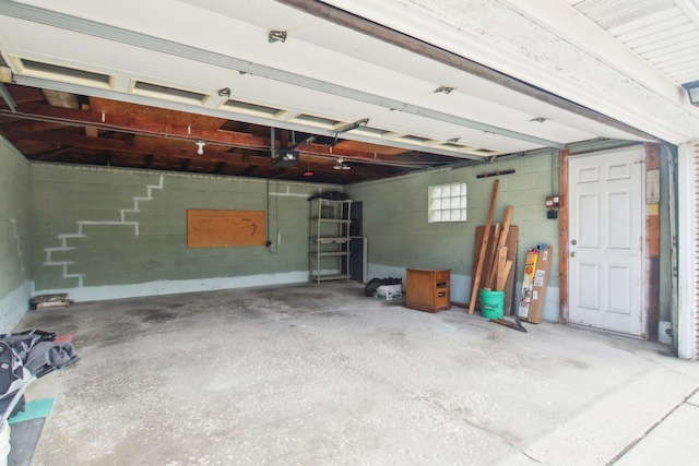 garage with concrete block wall and a garage door opener