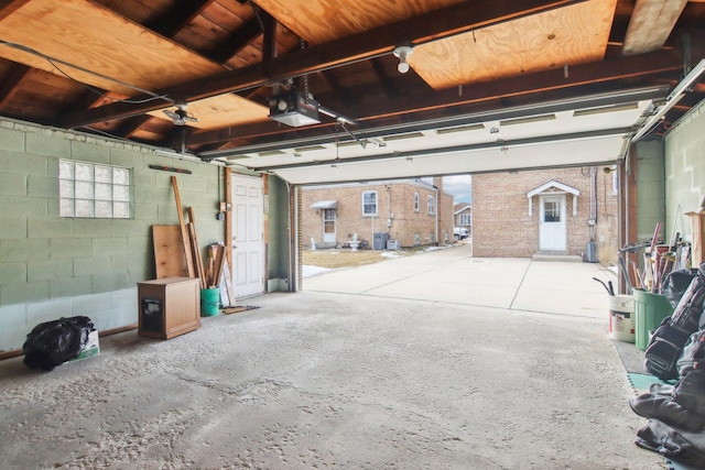 garage with a garage door opener and concrete block wall