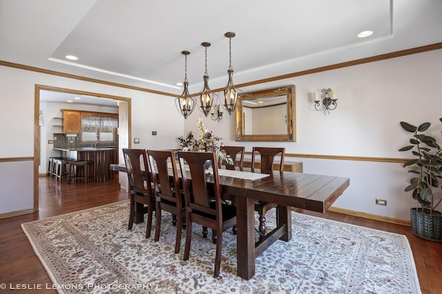 dining area featuring crown molding, a tray ceiling, dark hardwood / wood-style floors, and sink