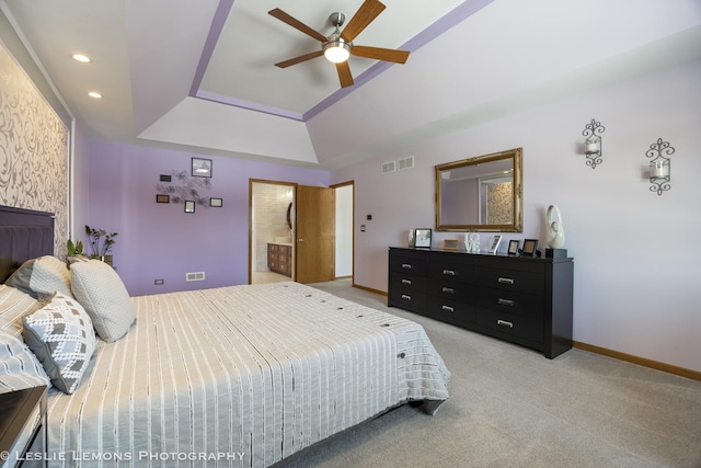 carpeted bedroom with ceiling fan and a tray ceiling