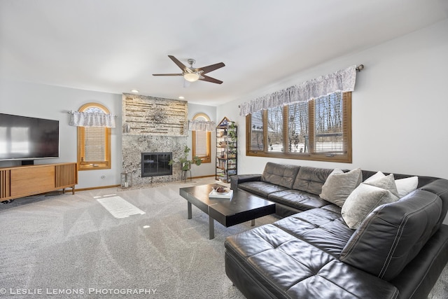 carpeted living room featuring ceiling fan and a high end fireplace