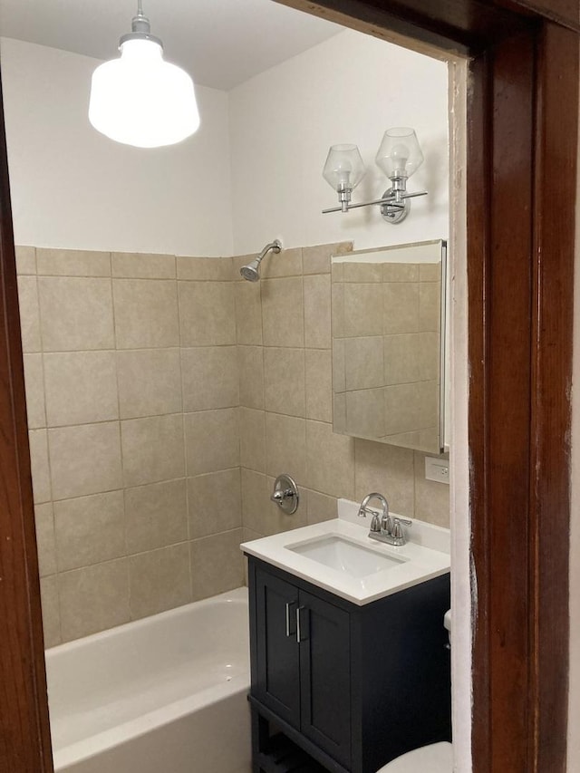 bathroom featuring vanity and tiled shower / bath