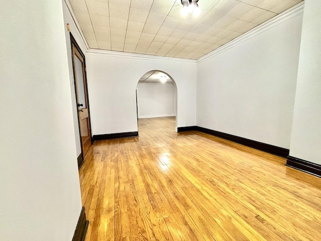 unfurnished room with crown molding and light wood-type flooring