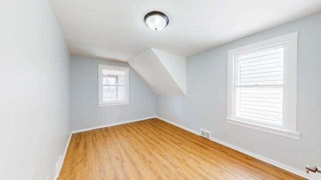 bonus room with lofted ceiling and light hardwood / wood-style flooring