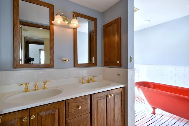 bathroom with double vanity, a soaking tub, a sink, and tile walls