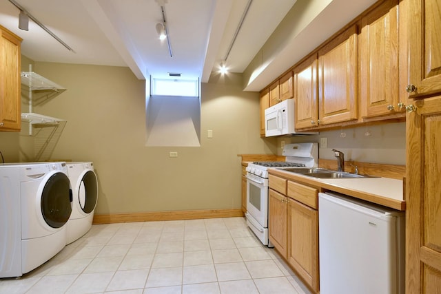 kitchen featuring white appliances, separate washer and dryer, a sink, and rail lighting