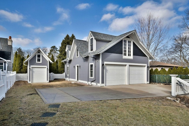 view of side of home with a garage, fence, and roof with shingles