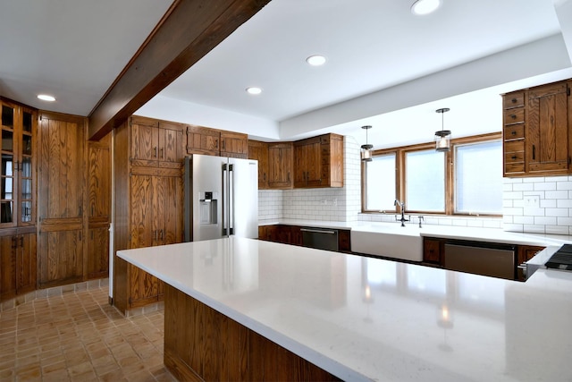 kitchen featuring appliances with stainless steel finishes, a sink, light countertops, backsplash, and recessed lighting