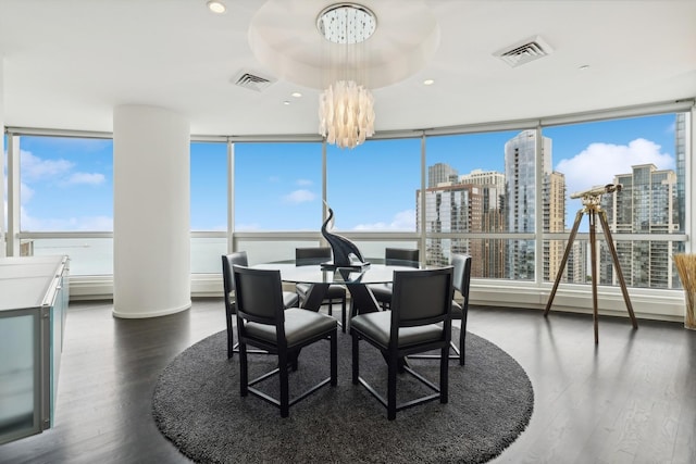 dining area with dark hardwood / wood-style flooring, a water view, and a chandelier