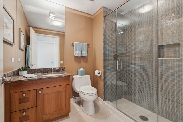 bathroom with vanity, tile patterned floors, a shower with door, and toilet