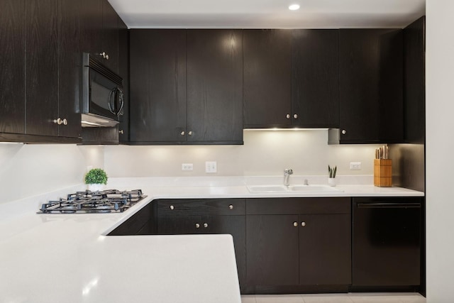 kitchen with dark brown cabinetry, sink, and black appliances