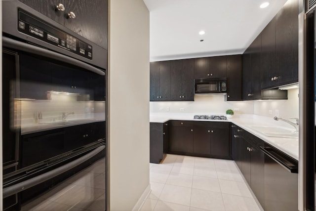 kitchen with dark brown cabinetry, sink, light tile patterned floors, and black appliances