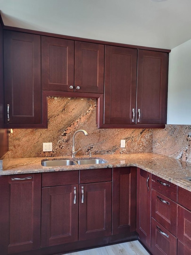 kitchen featuring light stone counters, sink, and decorative backsplash