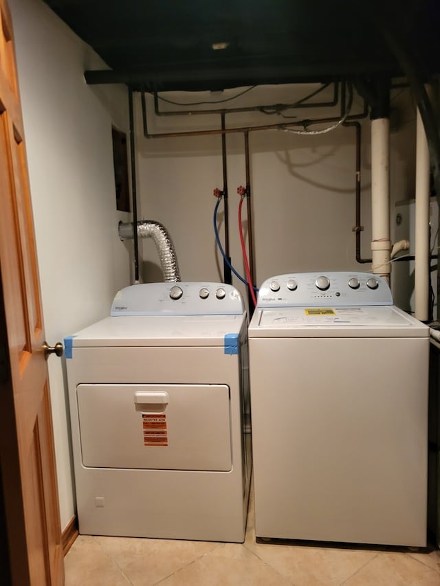 laundry area with washing machine and dryer and light tile patterned floors