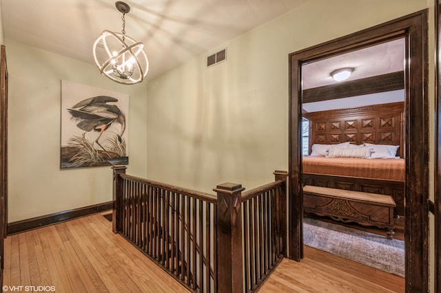 hall featuring a notable chandelier and light hardwood / wood-style floors