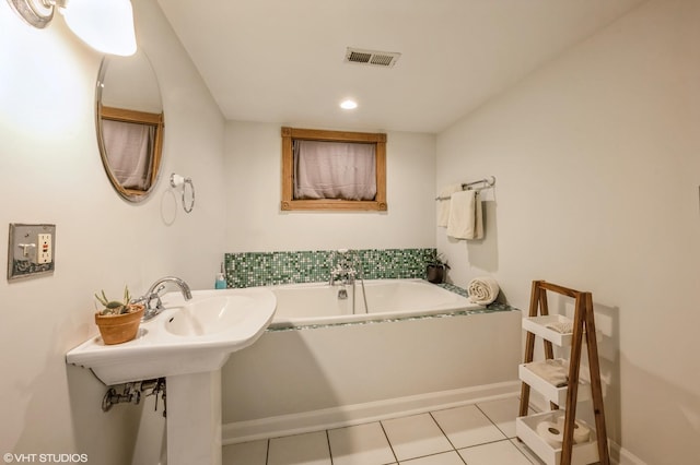 bathroom with tile patterned floors and a tub to relax in