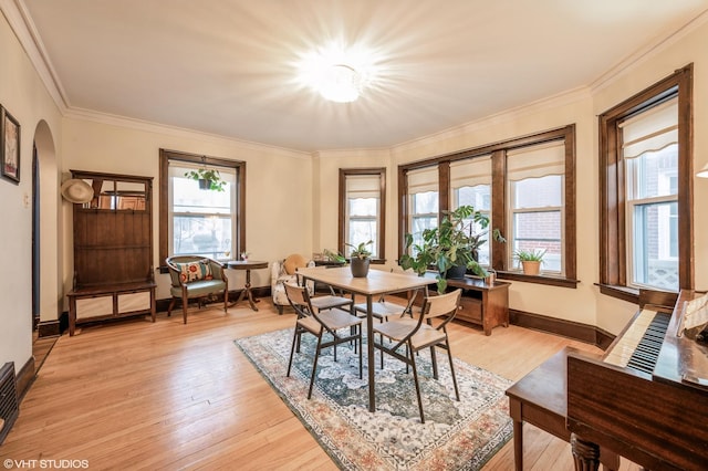 dining room featuring light hardwood / wood-style flooring and crown molding