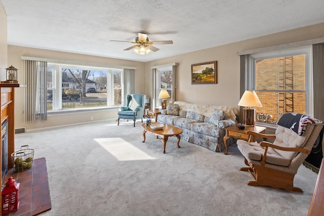 carpeted living room featuring ceiling fan and a textured ceiling