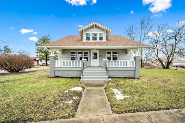 bungalow-style home featuring a front yard and covered porch