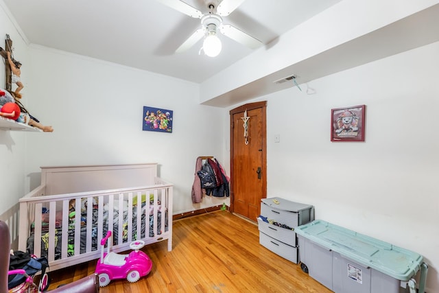 bedroom featuring ceiling fan, crown molding, and light wood-type flooring