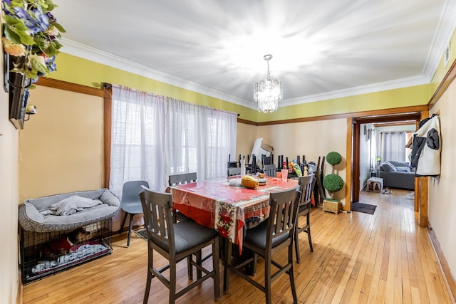 dining space featuring light hardwood / wood-style flooring, plenty of natural light, ornamental molding, and a chandelier