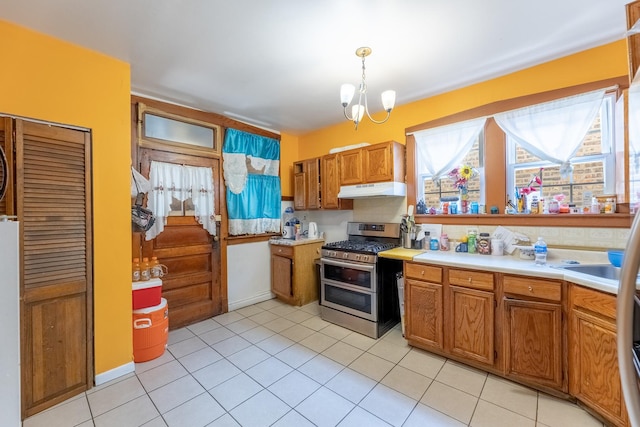 kitchen featuring pendant lighting, double oven range, light tile patterned flooring, and an inviting chandelier