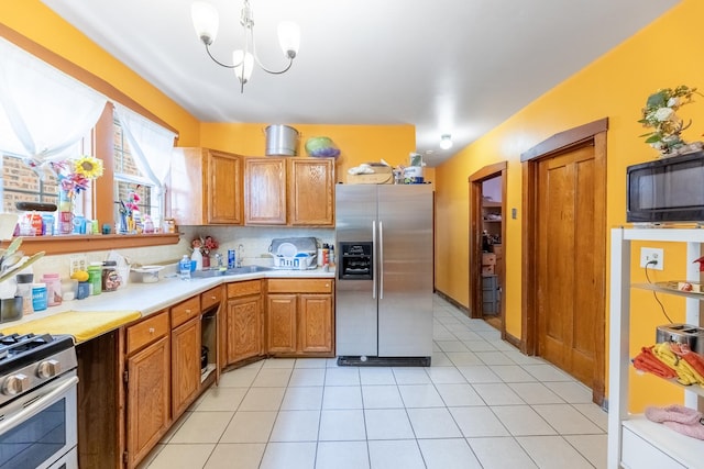 kitchen featuring light tile patterned flooring, sink, tasteful backsplash, a chandelier, and stainless steel appliances