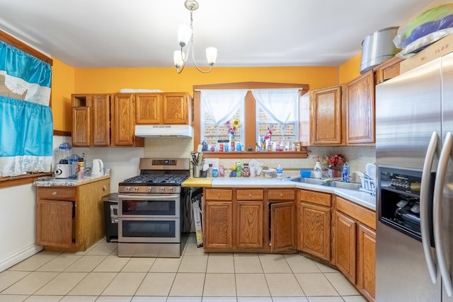 kitchen featuring sink, light tile patterned floors, stainless steel appliances, decorative light fixtures, and a chandelier