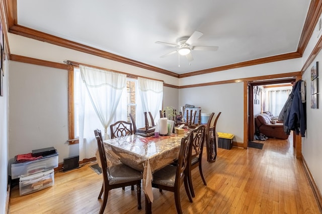 dining space with ceiling fan, ornamental molding, and light wood-type flooring