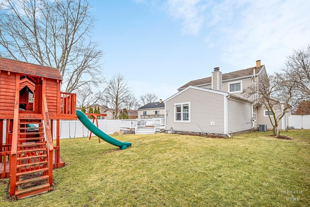 view of yard with cooling unit, a playground, and a fenced backyard