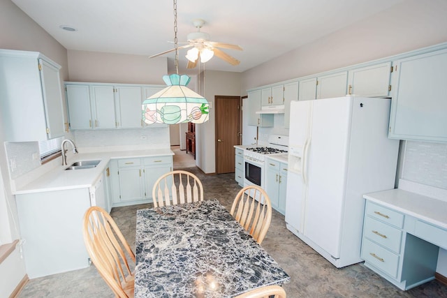 kitchen with light countertops, white appliances, backsplash, and a sink