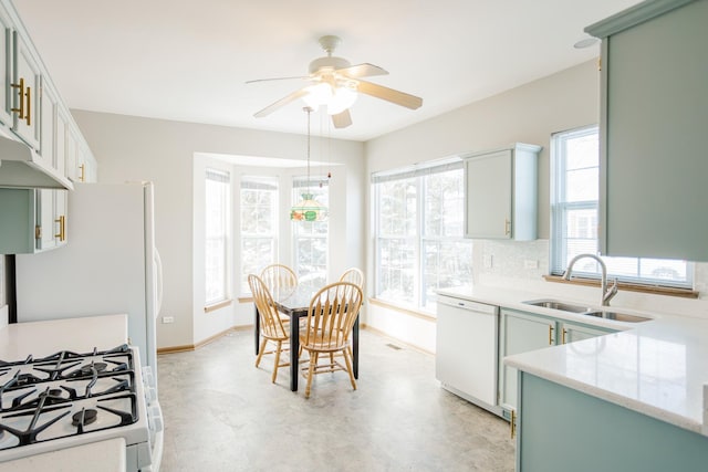 kitchen with sink, white appliances, ceiling fan, green cabinetry, and decorative backsplash