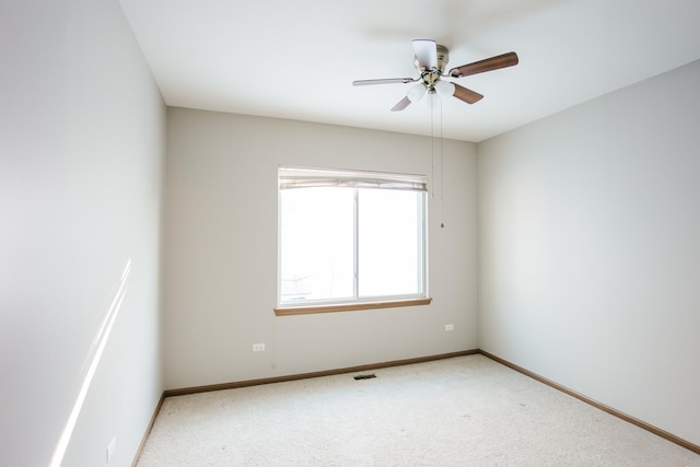 spare room with carpet floors, baseboards, visible vents, and ceiling fan