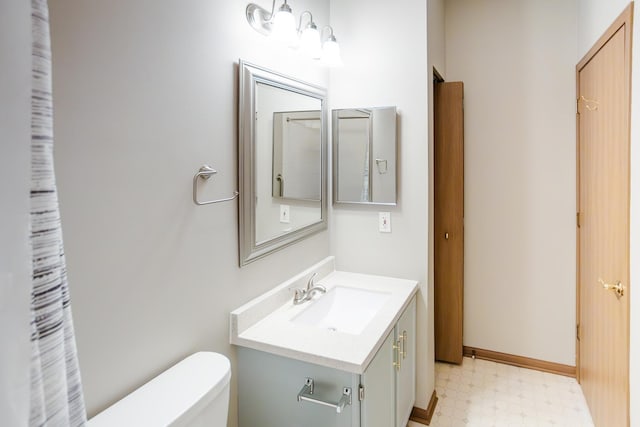 bathroom featuring toilet, vanity, baseboards, and tile patterned floors