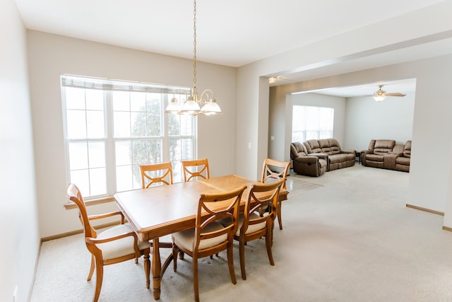 dining area with baseboards, a ceiling fan, and light colored carpet