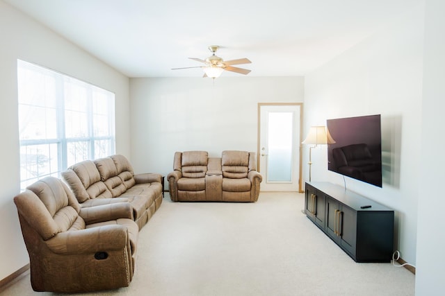 living room with light carpet, ceiling fan, and baseboards