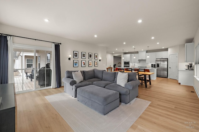 living room with recessed lighting and light wood-style flooring