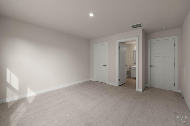 unfurnished bedroom with recessed lighting, visible vents, light carpet, ensuite bath, and baseboards