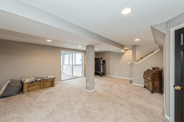 below grade area with recessed lighting, light carpet, a textured ceiling, and baseboards