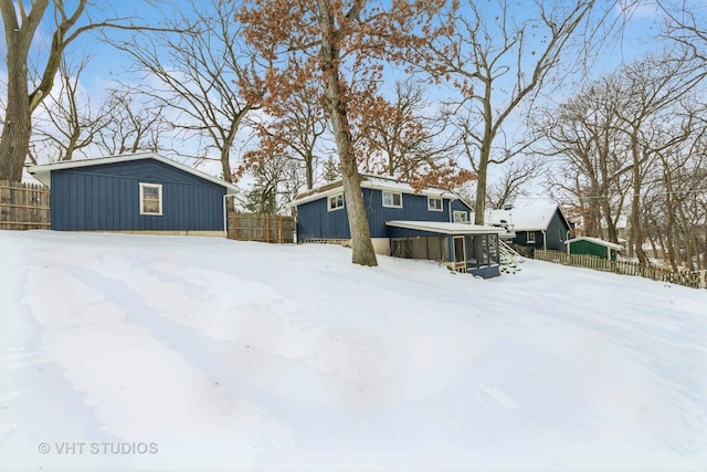 snowy yard featuring fence