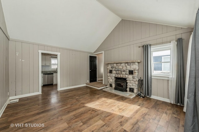 unfurnished living room featuring a healthy amount of sunlight, vaulted ceiling, and dark wood finished floors