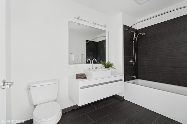 full bathroom with vanity, tiled shower / bath combo, and toilet