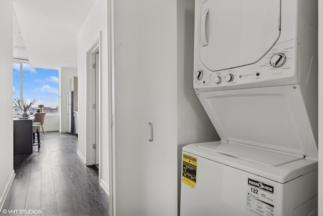 clothes washing area with stacked washer and clothes dryer and dark hardwood / wood-style flooring