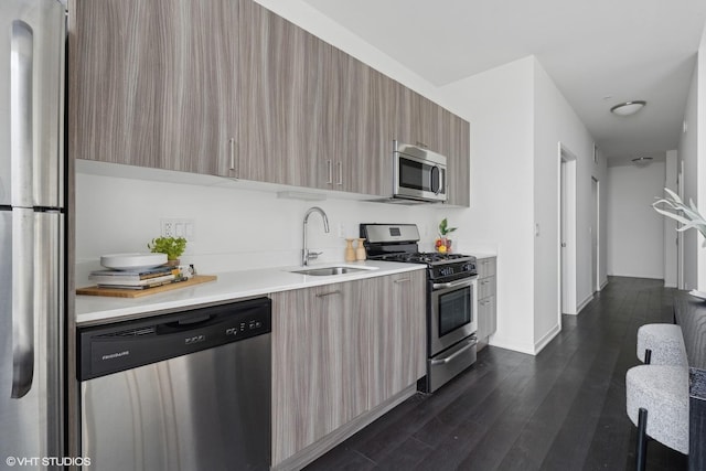 kitchen featuring stainless steel appliances, sink, and dark hardwood / wood-style floors