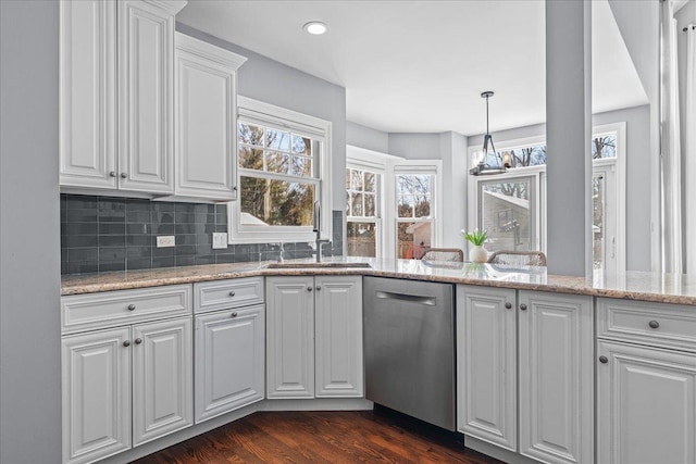 kitchen with white cabinets, hanging light fixtures, stainless steel dishwasher, light stone countertops, and dark wood finished floors